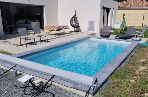 une piscine avec des chaises et une table dans l'établissement Chambre d'hôte, Au pays de cocagne !, à Saint-Lieux-lès-Lavaur