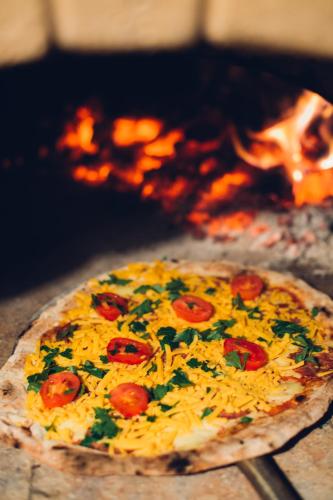 a pizza with tomatoes and parsley on a table at Kamagu Safari Lodge in Touwsrivier