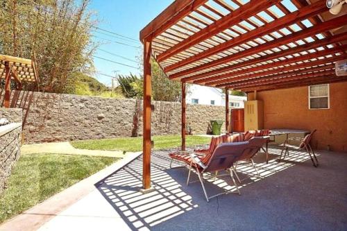 a patio with chairs and a wooden pergola at 3 BR + Near Venice Beach + Redecorated + Nice Backyard with BBQ in Los Angeles