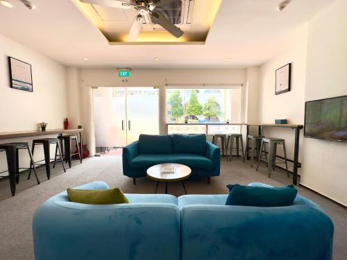 a living room with a blue couch and a table at Beary Best! Hostel Chinatown in Singapore