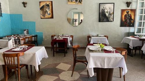 una sala da pranzo con tavoli, sedie e specchio di Hotel des cedres,azrou maroc ad Azrou
