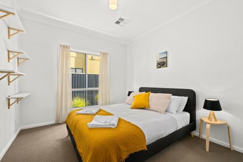 a bedroom with a bed with a yellow blanket at Ochre Sunsets - Moana - C21 SouthCoast Holidays in Moana