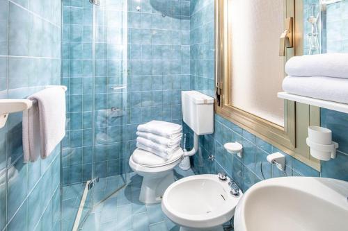 ビビオーネにあるAppartamenti Valentinaの青いタイル張りのバスルーム(トイレ、シンク付)