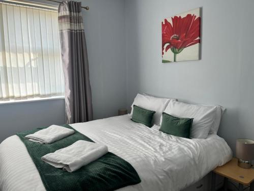a bedroom with a large bed with green and white pillows at The Island View - A1 in Berwick-Upon-Tweed