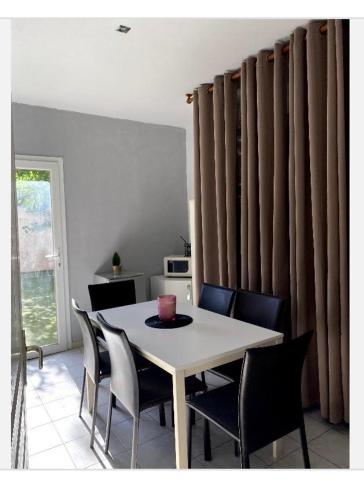 een eetkamer met een witte tafel en stoelen bij villa marina in Agde