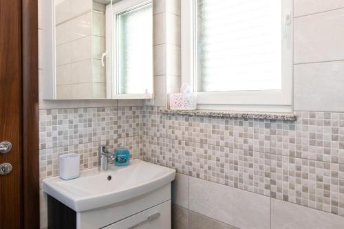 a bathroom with a sink and a mirror at House Zrile with garden and jacuzzi in Baška