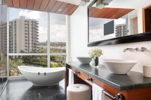 a bathroom with two sinks and a large window at The Ritz-Carlton Bal Harbour, Miami in Miami Beach