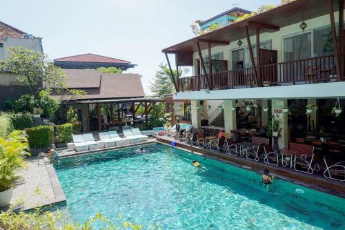 a swimming pool in front of a house at Graha Socio Hotel Nusa Dua Bali in Nusa Dua