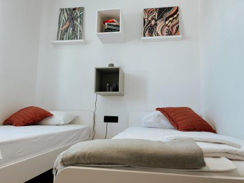 a bedroom with two beds and a tv on the wall at Dawn & Dusk - Modern Two Bedroom Apartment with Mountain Views in Čilipi