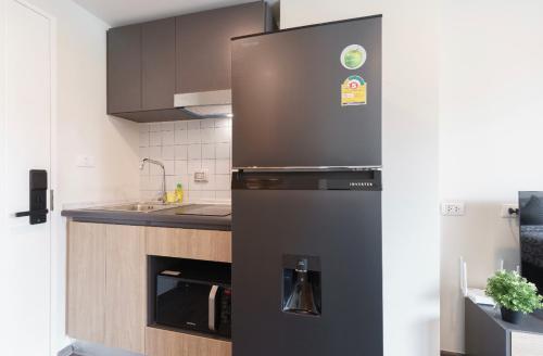 a black refrigerator in a kitchen with a sink at 沙吞Sathon-Charoen Nakhon精品公寓 in Bangkok