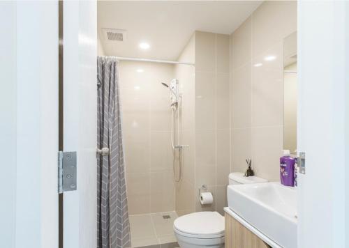 a white bathroom with a toilet and a shower at 沙吞Sathon-Charoen Nakhon精品公寓 in Bangkok