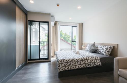 a bedroom with a bed and a sliding glass door at 沙吞Sathon-Charoen Nakhon精品公寓 in Bangkok