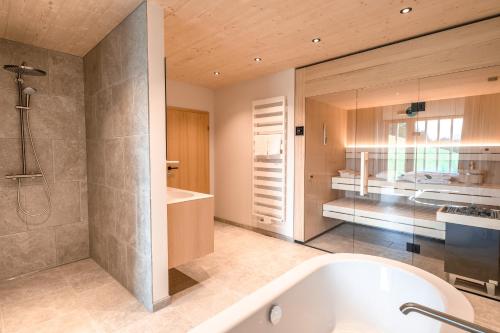 a bathroom with a bath tub and a bedroom at Freiheit in Bolsterlang