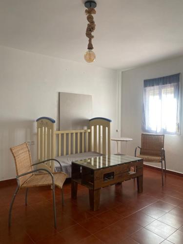 サアラ・デ・ラ・シエラにあるCasa Chiquiのベッド、テーブル、椅子が備わる客室です。