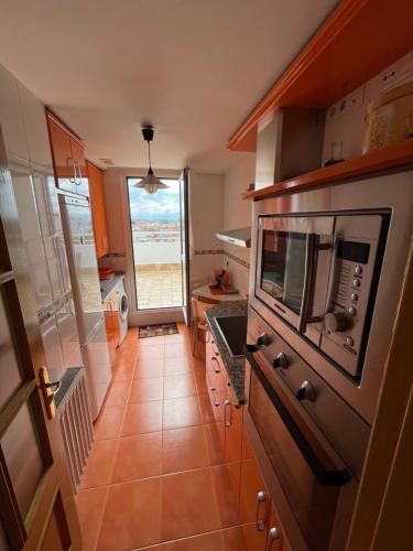 eine Küche mit einer Spüle und einer Mikrowelle in der Unterkunft Ático 360º de Burgos ATUAIRE in Burgos