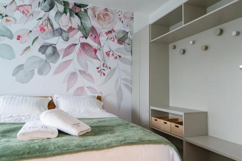ポッチェトルテクにあるMIZU APARTMA VAS LIPA OLIMJEの花柄の壁紙を用いたベッドルーム1室