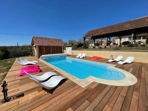 a swimming pool on a wooden deck with chairs around it at Le Clos Des Buis Gîte de Charme AZUL in Cazals
