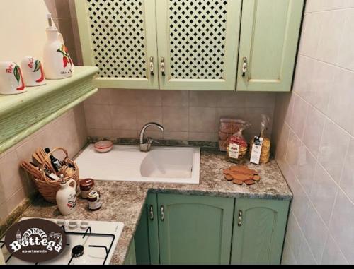 a kitchen with green cabinets and a sink at Casa & Bottega Apartments in Rossano