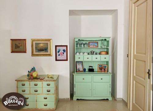 a room with a green cabinet and a dresser at Casa & Bottega Apartments in Rossano