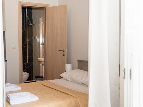 a bedroom with a bed and a bathroom with a shower at ALLAGIANNIS GROUP APARTMENTS in Markopoulo