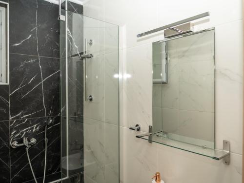 a bathroom with a shower with a glass door at ALLAGIANNIS GROUP APARTMENTS in Markopoulo
