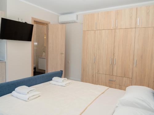 a bedroom with a bed with two towels on it at ALLAGIANNIS GROUP APARTMENTS in Markopoulo