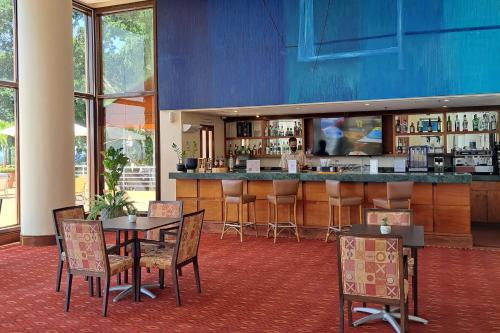 a restaurant with tables and chairs and a bar at Marriott Venezuela Hotel Playa Grande in Playa Grande