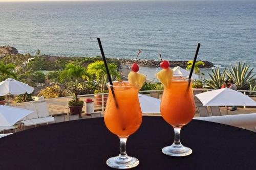 two drinks on a table with the ocean in the background at Marriott Venezuela Hotel Playa Grande in Playa Grande
