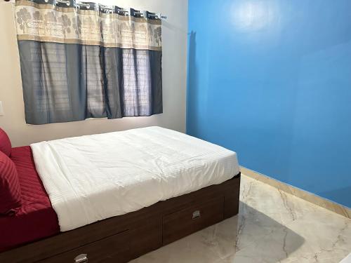 a bed in a room with a window at Anthara Service Apartment in Belūr