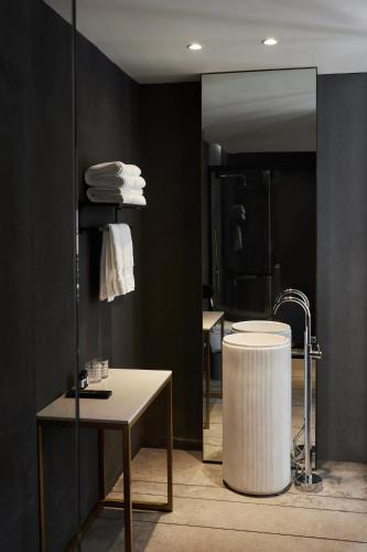 ein Badezimmer mit einer weißen Badewanne und einem Spiegel in der Unterkunft Cicer Cliff Sea View Villa in Dali