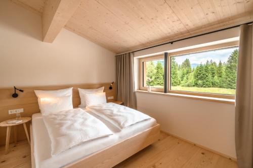 a bedroom with a bed with a large window at Freiheit in Bolsterlang