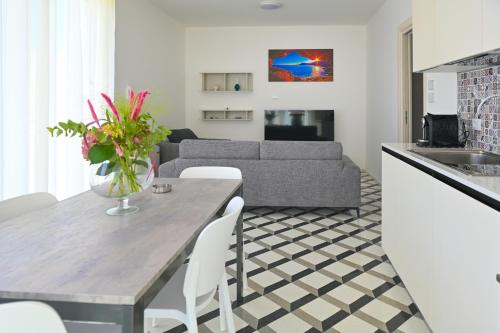 a kitchen and living room with a table and a couch at Perle Marine Suite Apartments in Castro di Lecce