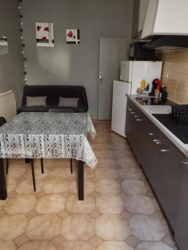 une cuisine avec une table au milieu dans l'établissement appartement centre ville, à Millau