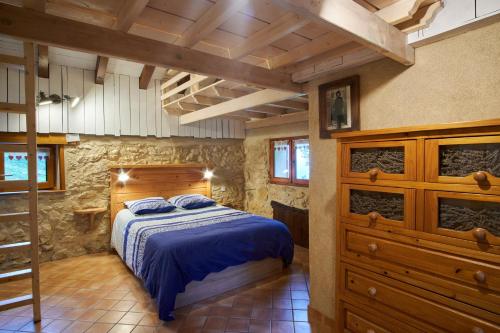 a bedroom with a bed and a stone wall at Maison de pierre in Saint-Gervais