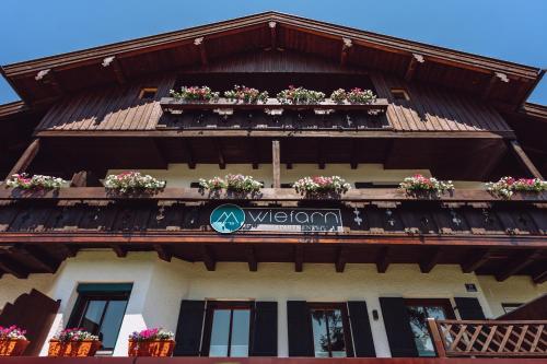 a building with flower boxes on the balcony at Wiefarn Apartments - Ferienwohnungen in Bad Wiessee am Tegernsee in Bad Wiessee