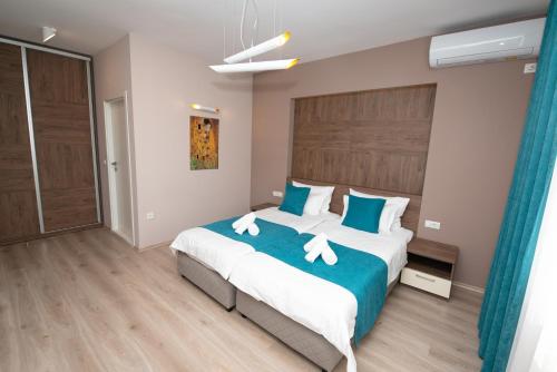 ein Schlafzimmer mit einem großen Bett mit blauen und weißen Kissen in der Unterkunft ZARO Apartments in Bitola