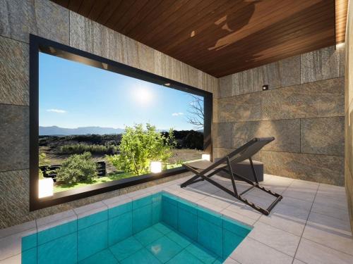 a swimming pool in a room with a large window at Yufuin Glamping COMOREBI in Yufuin