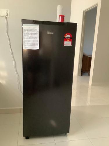 a black refrigerator with two stickers on it at Homestay Umi in Kijal