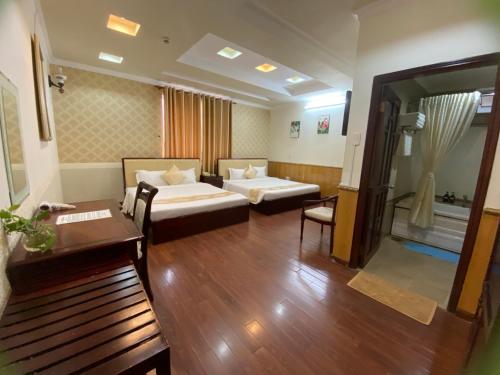 a hotel room with two beds and a living room at Linh Phuong 8 Hotel - 24 hours stay in Can Tho