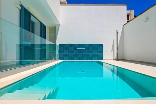 a swimming pool in a house with blue water at Perle Marine Suite Apartments in Castro di Lecce