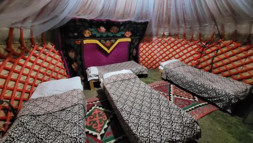 a room with two beds and a stage at Yurt Camp Ali-Nur, Lake Song-Kul , Kyrgyzstan, Юрточный лагерь Али Нур, на берегу озера Сон Кол in Naryn