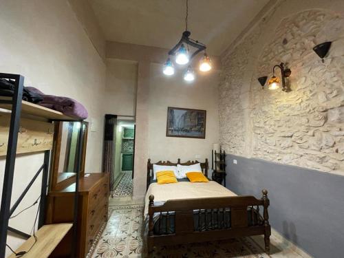 a bedroom with a bed and a stone wall at Alf leila wa leila boutique in Haifa