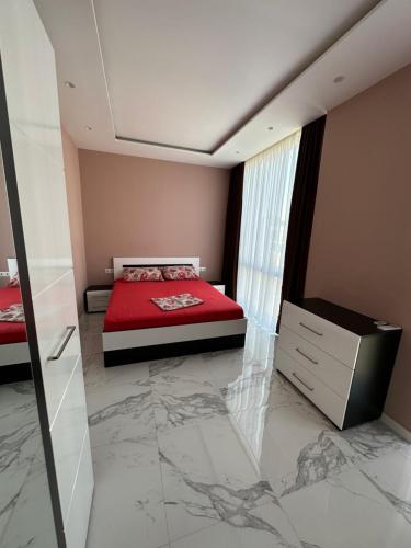 a bedroom with a red bed and a marble floor at Polo villas Batumi in Batumi
