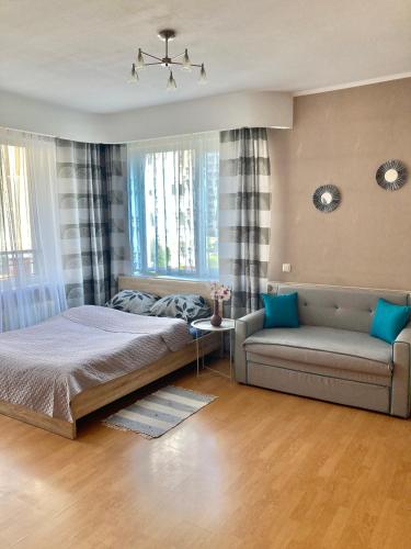 a bedroom with a bed and a couch at Apartment Saharova in Rīga