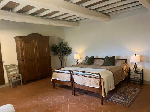 een slaapkamer met een bed en een stoel in een kamer bij Agriturismo Podere Querceto in Borselli