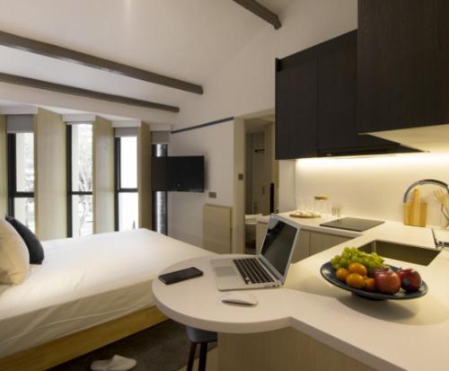 a bedroom with a laptop and a bowl of fruit on a counter at Coliwoo Keppel - CoLiving in Singapore