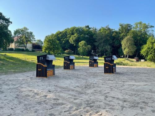 a group of dumpsters in the sand in a park at Neu möbliertes 1 - Zimmerapartment mitten in der Natur in Neu Gaarz