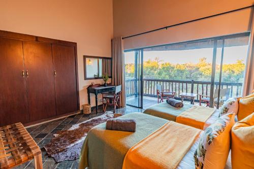 Cet appartement comprend une chambre avec deux lits et un balcon. dans l'établissement Kubu Lodge, à Mabula