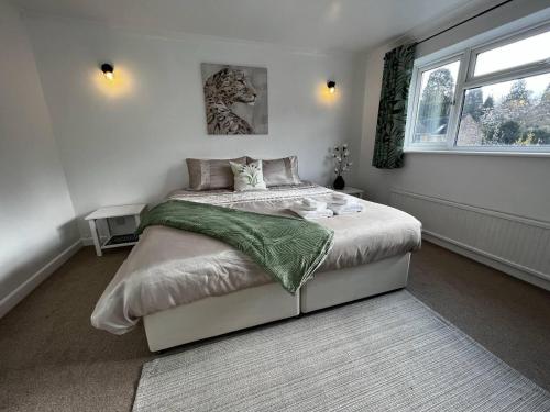 un dormitorio con una cama y una ventana en Charming 4-Bed House in Cheltenham Free Parking, en Cheltenham