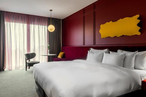 a hotel room with a large bed and a red wall at Tsinandali Estate, A Radisson Collection Hotel in Tsinandali